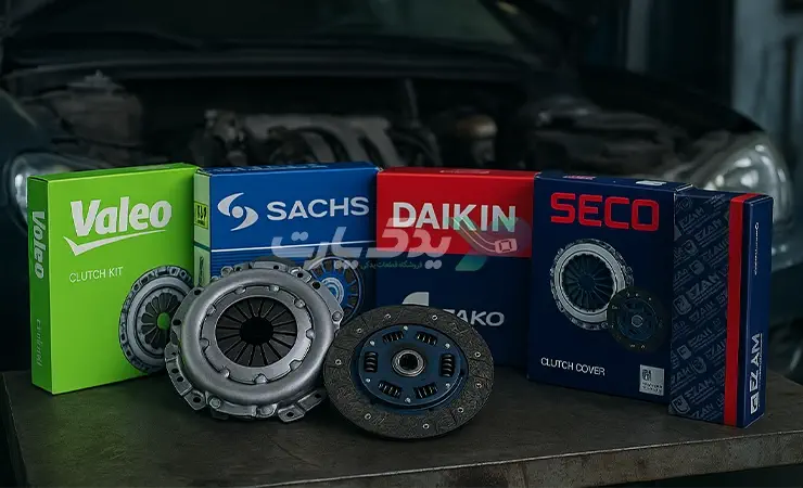 چند جعبه دیسک و صفحه برندهای مختلف شامل Valeo، LUK، Sachs، Daikin، SECO و عظام همراه با یک دیسک و صفحه باز روی میز مکانیک با پس‌زمینه موتور خودرو